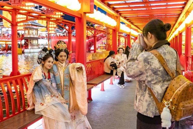 (261006) -- BEIJING, Oct. 6, 2026 (Xinhua) -- Tourists pose for a photo at the Hetou Old Street scenic area in Fengnan District of Tangshan City, north China's Hebei Province, Oct. 3, 2026. During the National Day holiday, night tours were launched across China to create diversified consumption scenes. (Photo by Li Xiuqing/Xinhua)