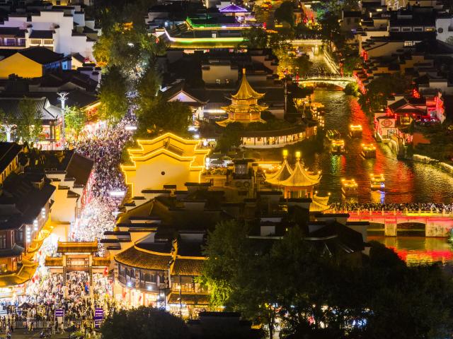 (261006) -- BEIJING, Oct. 6, 2026 (Xinhua) -- An aerial drone photo taken on Oct. 5, 2026 shows people visiting the Fuzi (Confucius) Temple scenic area in Nanjing, east China's Jiangsu Province. During the National Day holiday, night tours were launched across China to create diversified consumption scenes. (Photo by Shi Jun/Xinhua)
