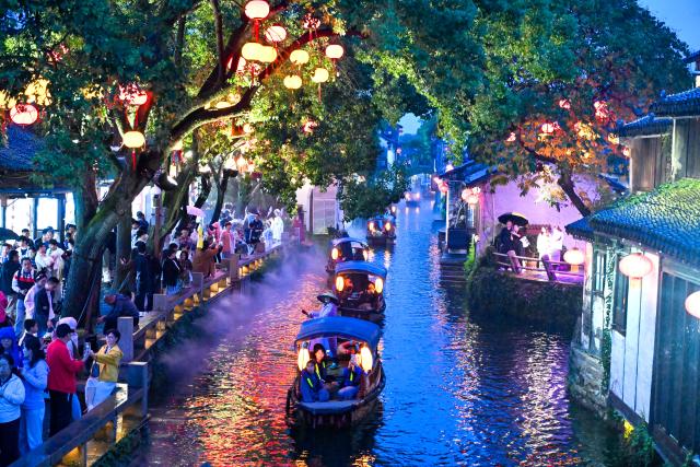 (261006) -- BEIJING, Oct. 6, 2026 (Xinhua) -- Tourists visit the ancient town of Zhouzhuang, Kunshan City, east China's Jiangsu Province, Oct. 3, 2026. During the National Day holiday, night tours were launched across China to create diversified consumption scenes. (Photo by Yang Suping/Xinhua)