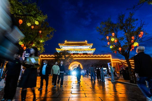 (261006) -- BEIJING, Oct. 6, 2026 (Xinhua) -- People visit a scenic spot in Shangqiu, central China's Henan Province, Oct. 4, 2026. During the National Day holiday, night tours were launched across China to create diversified consumption scenes. (Photo by Li Heng/Xinhua)