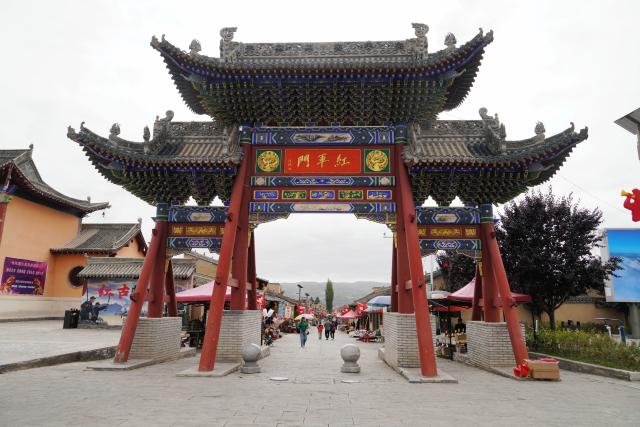 (261006) -- DANGCHANG, Oct. 6, 2026 (Xinhua) -- This photo taken on Oct. 4, 2026 shows a gate marking the Red Army's Long March at the ancient town of Hadapu in Dangchang County, Longnan City of northwest China's Gansu Province. Hadapu Town was an important stop on the Red Army's Long March. Integrating revolutionary history tourism resources with ancient-town commerce and characteristic agriculture, the town has advanced cultural heritage conservation, preserved the ancient town, and boosted local people's income. (Photo by Liu Hui/Xinhua)
