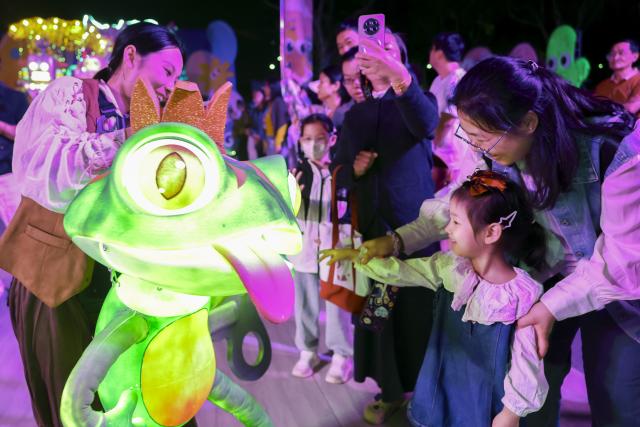 (261006) -- SHANGHAI, Oct. 6, 2026 (Xinhua) -- A kid interacts with a puppet during the 10th "Golden Magnolia" Shanghai International Puppet Art Week in east China's Shanghai, Oct. 5, 2026. The art week, themed "See the World, See You and Me, Enjoy the Future," opened here on Monday. (Xinhua/Wang Xiang)