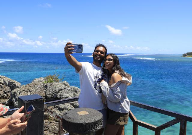 (261006) -- PORT LOUIS, Oct. 6, 2026 (Xinhua) -- People take selfies by the seaside in Savanne District, Mauritius, Oct. 5, 2026. (Xinhua/Chen Wei)