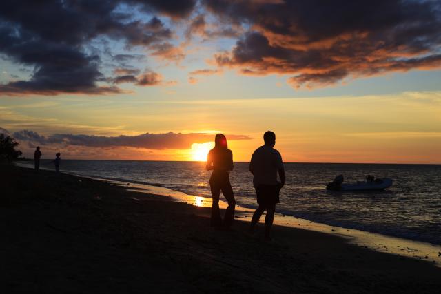 (261006) -- PORT LOUIS, Oct. 6, 2026 (Xinhua) -- People enjoy the scenery at sunset on a beach in Black River District, Mauritius, Oct. 2, 2026. (Xinhua/Chen Wei)