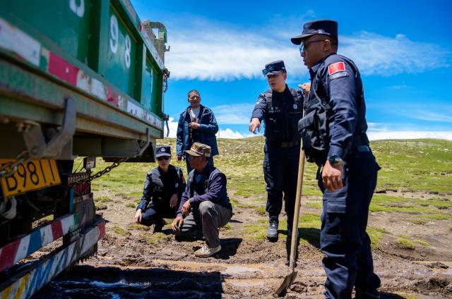 (261006) -- LHASA, Oct. 6, 2026 (Xinhua) -- Police officers of the Pumaqangtang border police station help a man free his truck from being stuck in Shannan, southwest China's Xizang Autonomous Region, Aug. 19, 2026. Pumaqangtang, China's highest township, has an average altitude of 5,373 meters, with oxygen levels less than a half of that at sea level.
   Here stands the Pumaqangtang border police station, the highest-altitude border police station in China. Police and auxiliary police officers here, with an average age of just over 30, hold their posts on the frigid, oxygen-thin plateau. (Xinhua/Tenzin Nyida)