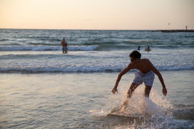 (261006) -- TEL AVIV, Oct. 6, 2026 (Xinhua) -- A man surfs along the seashore in Tel Aviv, Israel, Oct. 4, 2026. The latest round of Gaza conflict will mark its third anniversary on Oct. 7. (Xinhua/Chen Junqing)