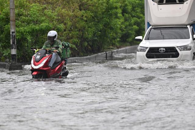 (261006) -- BANGKOK, Oct. 6, 2026 (Xinhua) -- A take-out driver rides a motorcycle through floodwater in Bangkok, Thailand on Oct. 6, 2026. Floods across Thailand have killed 31 people and affected about 4.14 million others since Sept. 16, authorities said on Monday. (Xinhua/Rachen Sageamsak)