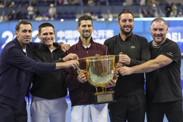 (261006) -- BEIJING, Oct. 6, 2026 (Xinhua) -- Winner Novak Djokovic of Serbia poses for photos with his team staff after the awarding ceremony for the men's singles final at 2026 China Open tennis tournament in Beijing, China, Oct. 6, 2026. (Xinhua/Bai Xuefei)