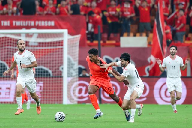 (261006) -- CHONGQING, Oct. 6, 2026 (Xinhua) -- Shervoni Mabatshoev (R) of Tajikistan vies with Huang Shenghao of China during the CFA Team China International Football Competitions Chongqing 2026 between China and Tajikistan in Chongqing, Oct. 6, 2026. (Xinhua/Huang Wei)