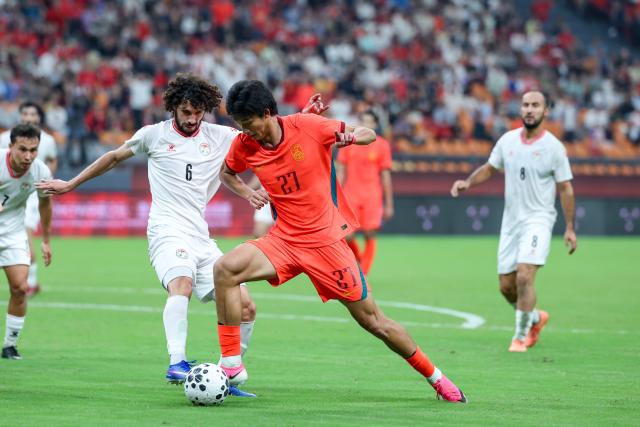 (261006) -- CHONGQING, Oct. 6, 2026 (Xinhua) -- Zhao Songyuan (R) of China vies with Vahdat Hanonov of Tajikistan during the CFA Team China International Football Competitions Chongqing 2026 between China and Tajikistan in Chongqing, Oct. 6, 2026. (Xinhua/Huang Wei)
