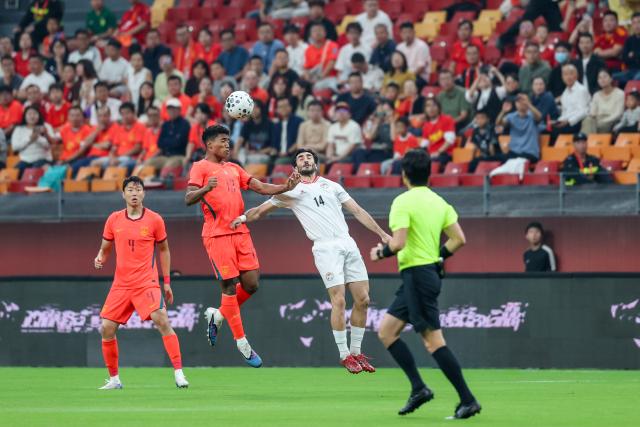 (261006) -- CHONGQING, Oct. 6, 2026 (Xinhua) -- Huang Shenghao (2nd L) of China and Sheriddin Boboev of Tajikistan head for the ball during the CFA Team China International Football Competitions Chongqing 2026 between China and Tajikistan in Chongqing, Oct. 6, 2026. (Xinhua/Huang Wei)