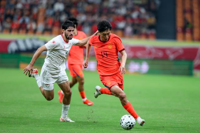 (261006) -- CHONGQING, Oct. 6, 2026 (Xinhua) -- Liu Yang (R) of China vies with Shervoni Mabatshoev of Tajikistan during the CFA Team China International Football Competitions Chongqing 2026 between China and Tajikistan in Chongqing, Oct. 6, 2026. (Xinhua/Huang Wei)