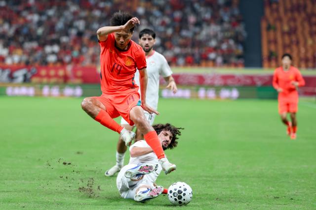 (261006) -- CHONGQING, Oct. 6, 2026 (Xinhua) -- Liu Yang (top) of China vies with Vahdat Hanonov of Tajikistan during the CFA Team China International Football Competitions Chongqing 2026 between China and Tajikistan in Chongqing, Oct. 6, 2026. (Xinhua/Huang Wei)