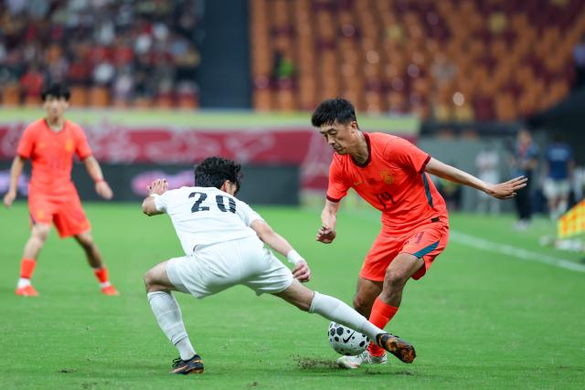 (261006) -- CHONGQING, Oct. 6, 2026 (Xinhua) -- Alijon Karomatullozoda (L) of Tajikistan vies with Liu Yang of China during the CFA Team China International Football Competitions Chongqing 2026 between China and Tajikistan in Chongqing, Oct. 6, 2026. (Xinhua/Huang Wei)