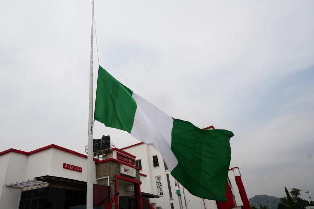 (261006) -- ABUJA, Oct. 6, 2026 (Xinhua) -- This photo taken on Oct. 6, 2026 shows a national flag flying at half-mast in front of a building in Abuja, Nigeria, in mourning for the victims of a military aircraft crash. TO GO WITH "Nigeria declares 3-day mourning for 32 military personnel killed in plane crash" (Photo by Amzat Adewale/Xinhua)