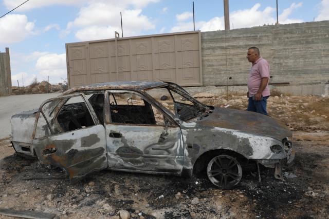 (261006) -- HEBRON, Oct. 6, 2026 (Xinhua) -- A Palestinian man inspects a vehicle burnt by Israeli settlers in the town of al-Samu, south of Hebron in the West Bank, Oct. 6, 2026. (Photo by Mamoun Wazwaz/Xinhua)