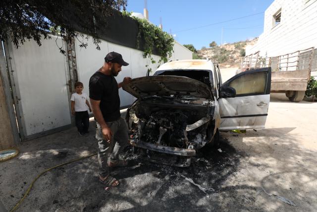 (261006) -- NABLUS, Oct. 6, 2026 (Xinhua) -- A Palestinian inspects a vehicle burnt by Israeli settlers in the village of Aqraba, south of Nablus, in the West Bank, Oct. 6, 2026. (Photo by Nidal Eshtayeh/Xinhua)