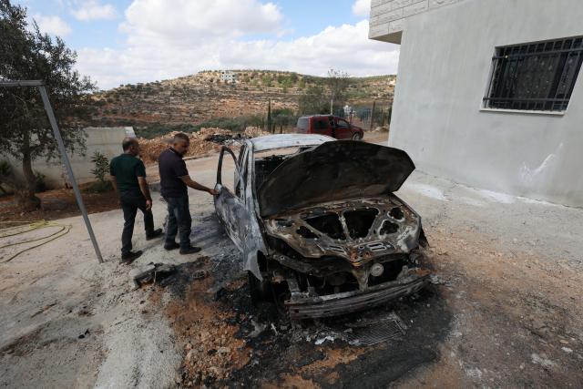 (261006) -- NABLUS, Oct. 6, 2026 (Xinhua) -- Palestinians inspect a vehicle burnt by Israeli settlers in the village of Aqraba, south of Nablus, in the West Bank, Oct. 6, 2026. (Photo by Nidal Eshtayeh/Xinhua)