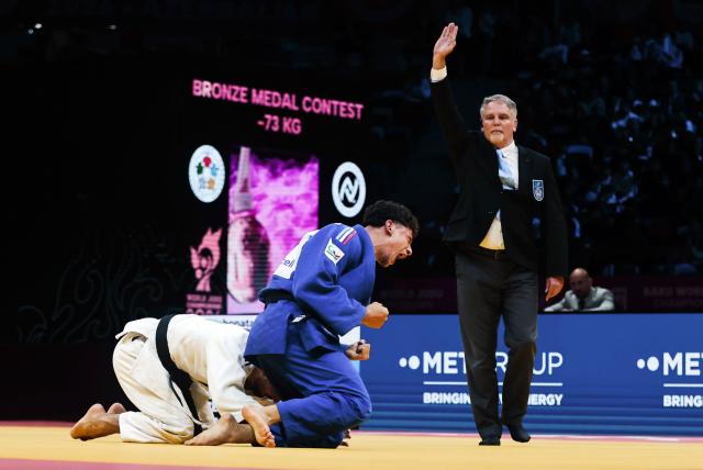 (261007) -- BAKU, Oct. 7, 2026 (Xinhua) -- Dayyan Boulemtafes of France (front) celebrates his victory against Yehonatan Elbaz of Israel during the bronze medal bout of men's -73kg at the 2026 World Senior Judo Championships in Baku on Oct. 6, 2026. (Xinhua/Chen Junfeng)
