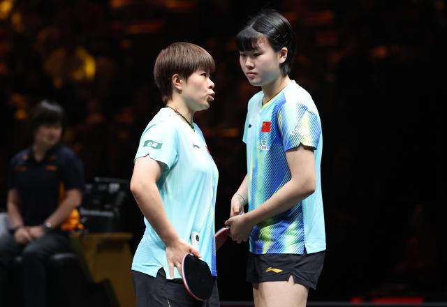 (261007) -- BEIJING, Oct. 7, 2026 (Xinhua) -- Wang Yidi (L)/Jiang Yiyi of China react during the women's doubles round of 16 match between Wang Yidi/Jiang Yiyi of China and Shin Yubin/Joo Cheonhui of South Korea at 2026 World Table Tennis (WTT) China Smash in Beijing, China, Oct. 7, 2026. (Xinhua/Zhang Chenlin)