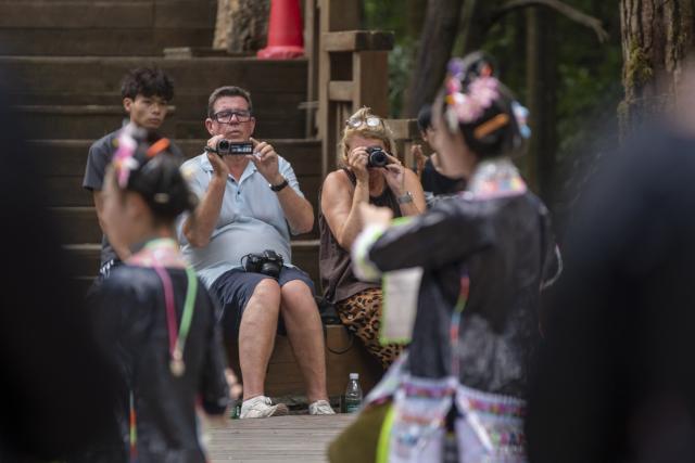 (261007) -- CONGJIANG, Oct. 7, 2026 (Xinhua) -- Visitors enjoy a folk performance at Basha Village in Congjiang County of Qiandongnan Miao and Dong Autonomous Prefecture, southwest China's Guizhou Province, Aug. 22, 2026. Located seven kilometers away from the county seat of Congjiang, Basha Village has attracted an increasing number of overseas tourists with its charming scenery and simple folk customs recently. 
   Consisting of five hamlets and inhabited by the Miao people, the village was included in the first batch of China's traditional villages in 2012. Riding the viral "Chinamaxxing" wave on social media, foreign tourists have come here to experience ancient ways of life and profound cultural heritage. 
   Data from the National Immigration Administration shows that China recorded 22.91 million inbound foreign visits in the first half of this year, up 20.4 percent year on year. (Photo by Wu Dejun/Xinhua)