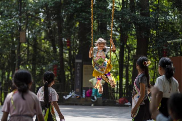(261007) -- CONGJIANG, Oct. 7, 2026 (Xinhua) -- A girl has fun on a swing at Basha Village in Congjiang County of Qiandongnan Miao and Dong Autonomous Prefecture, southwest China's Guizhou Province, Aug. 7, 2026. Located seven kilometers away from the county seat of Congjiang, Basha Village has attracted an increasing number of overseas tourists with its charming scenery and simple folk customs recently. 
   Consisting of five hamlets and inhabited by the Miao people, the village was included in the first batch of China's traditional villages in 2012. Riding the viral "Chinamaxxing" wave on social media, foreign tourists have come here to experience ancient ways of life and profound cultural heritage. 
   Data from the National Immigration Administration shows that China recorded 22.91 million inbound foreign visits in the first half of this year, up 20.4 percent year on year. (Photo by Wu Dejun/Xinhua)