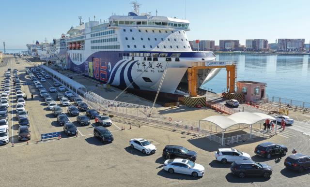 (261007) -- BEIJING, Oct. 7, 2026 (Xinhua) -- A drone photo taken on Oct. 7, 2026 shows vehicles lining up to enter a ro-ro passenger ship at Yantai Port in Yantai, east China's Shandong Province. As the National Day holiday is drawing to a close, return travel flows increase across the country. (Photo by Tang Ke/Xinhua)