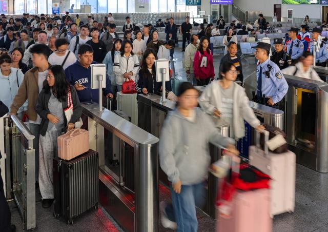 (261007) -- BEIJING, Oct. 7, 2026 (Xinhua) -- Passengers check in at Tongren South Railway Station in Tongren City, southwest China's Guizhou Province, Oct. 7, 2026. As the National Day holiday is drawing to a close, return travel flows increase across the country. (Photo by Hu Panxue/Xinhua)