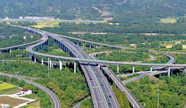 (261007) -- BEIJING, Oct. 7, 2026 (Xinhua) -- An aerial drone photo taken on Oct. 7, 2026 shows vehicles running on an expressway in Baita Town of Xianju County, Taizhou City, east China's Zhejiang Province. As the National Day holiday is drawing to a close, return travel flows increase across the country. (Photo by Wang Huabin/Xinhua)