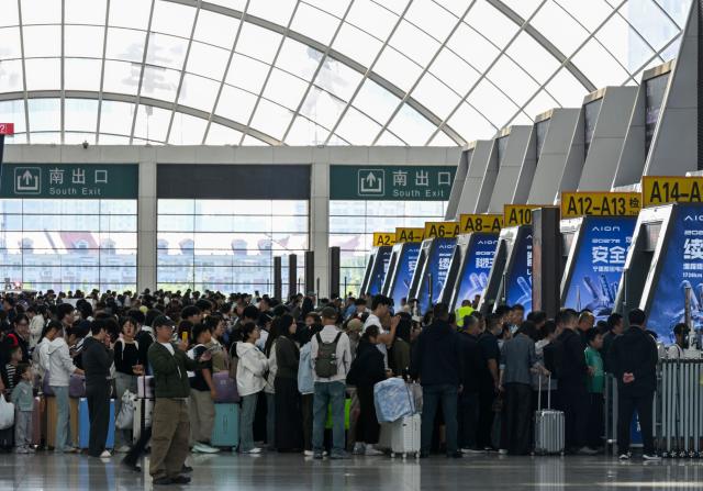 (261007) -- BEIJING, Oct. 7, 2026 (Xinhua) -- Passengers line up for check-in at the waiting hall of Tianjin West Railway Station in north China's Tianjin, Oct. 7, 2026. As the National Day holiday is drawing to a close, return travel flows increase across the country. (Xinhua/Zhao Zishuo)