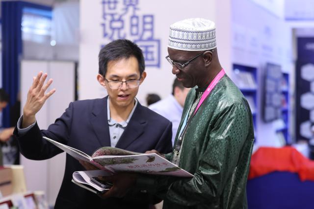(261007) -- FRANKFURT, Oct. 7, 2026 (Xinhua) -- A reader (R) talks to a staff member at the Chinese joint exhibition booth of the Frankfurt Book Fair in Frankfurt, Germany, Oct. 7, 2026. The world's largest book fair opened Wednesday in Frankfurt, Germany, bringing together more than 4,000 publishing institutions from over 100 countries and regions.
  The Chinese joint exhibition booth covers 336 square meters and features more than 3,000 titles and over 4,600 copies of selected books. It combines book displays, rights negotiations, cultural exchanges and interactive experiences. (Xinhua/Du Zheyu)