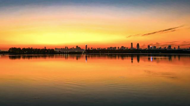 (261008) -- WUHAN, Oct. 8, 2026 (Xinhua) -- This photo taken with a mobile phone on Oct. 7, 2026 shows the East Lake at sunset in Wuhan, central China's Hubei Province. (Xinhua/Shen Hongbing)