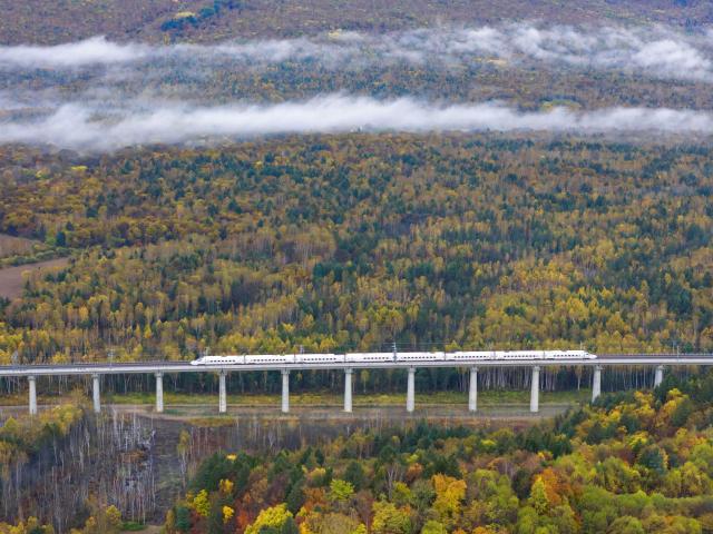 (261008) -- YICHUN, Oct. 8, 2026 (Xinhua) -- An aerial drone photo taken on Oct. 1, 2026 shows a bullet train of Harbin-Yichun high-speed railway running through forests in autumn scenery in Yichun, northeast China's Heilongjiang Province. The Harbin-Yichun high-speed railway, China's northernmost high-speed railway which officially entered service on Sept. 28, underlines the country's efforts to direct more transport infrastructure investment toward border areas, forest regions and less-developed regions, while helping boost development and prosperity in northeast China's border regions. (Photo by Li Shaojun/Xinhua)