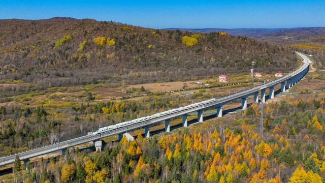 (261008) -- YICHUN, Oct. 8, 2026 (Xinhua) -- An aerial drone photo taken on Oct. 6, 2026 shows a bullet train of Harbin-Yichun high-speed railway running through forests in autumn scenery in Yichun, northeast China's Heilongjiang Province. The Harbin-Yichun high-speed railway, China's northernmost high-speed railway which officially entered service on Sept. 28, underlines the country's efforts to direct more transport infrastructure investment toward border areas, forest regions and less-developed regions, while helping boost development and prosperity in northeast China's border regions. (Photo by Yuan Yong/Xinhua)
