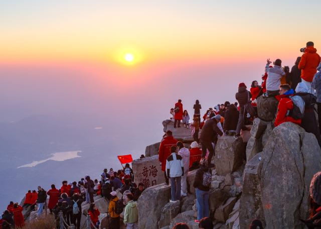 (261008) -- TAI'AN, Oct. 8, 2026 (Xinhua) -- Tourists watch the sunrise at the scenic area of Mount Tai in Tai'an, east China's Shandong Province, Oct. 8, 2026. (Xinhua/Chen Yehua)