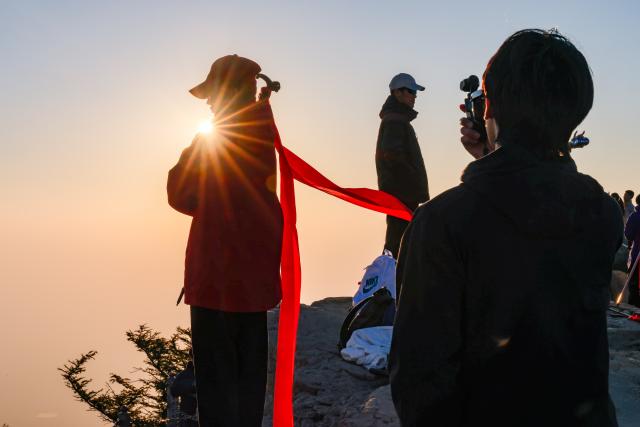 (261008) -- TAI'AN, Oct. 8, 2026 (Xinhua) -- Tourists make a pose at the scenic area of Mount Tai in Tai'an, east China's Shandong Province, Oct. 8, 2026. (Xinhua/Chen Yehua)