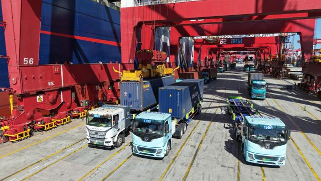 (261008) -- QINGDAO, Oct. 8, 2026 (Xinhua) -- A drone photo taken on Oct. 8, 2026 shows freight trucks at a container terminal of Qingdao Port in Qingdao, east China's Shandong Province. As an international shipping hub in Northeast Asia, Qingdao Port has been expanding its shipping network, adding 16 foreign trade routes so far this year. The port now operates nearly 240 foreign trade routes, connecting over 700 ports in over 180 countries and regions. (Xinhua/Li Ziheng)