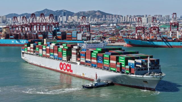 (261008) -- QINGDAO, Oct. 8, 2026 (Xinhua) -- A drone photo taken on Oct. 8, 2026 shows a cargo ship departing from Qingdao Port in Qingdao, east China's Shandong Province. As an international shipping hub in Northeast Asia, Qingdao Port has been expanding its shipping network, adding 16 foreign trade routes so far this year. The port now operates nearly 240 foreign trade routes, connecting over 700 ports in over 180 countries and regions. (Xinhua/Li Ziheng)