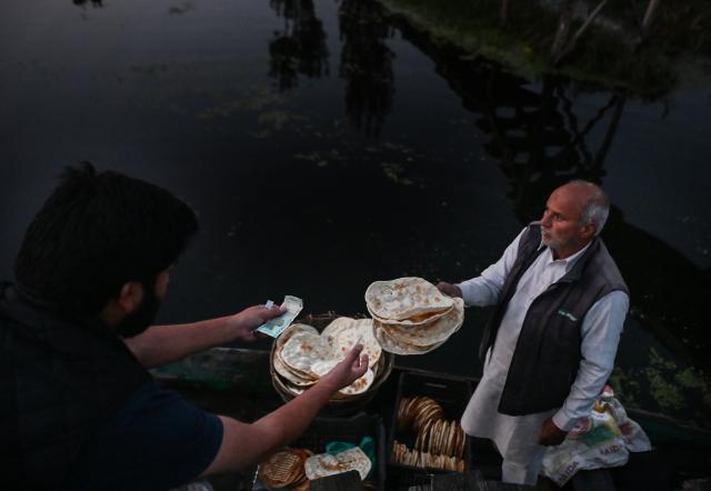 (261008) -- SRINAGAR, Oct. 8, 2026 (Xinhua) -- A bread vendor sells traditional Kashmiri breads from a boat in the early morning on Dal Lake in Srinagar, the summer capital of Indian-controlled Kashmir, Oct. 8, 2026. (Xinhua/Javed Dar)