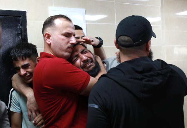 (261008) -- NABLUS, Oct. 8, 2026 (Xinhua) -- Relatives of a Palestinian farmer who was killed in an Israeli attack mourn at Rafidia Hospital in the West Bank city of Nablus, on Oct. 7, 2026. TO GO WITH "Five Palestinians killed in Israeli attacks in Gaza, West Bank " (Photo by Ayman Nobani/Xinhua)