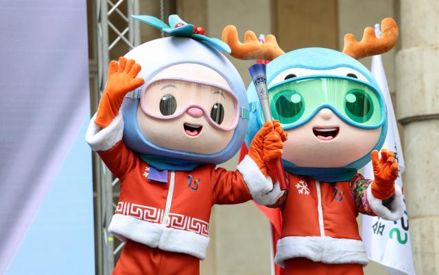 (261009) -- TURIN, Oct. 9, 2026 (Xinhua) -- The mascots "Ji Bing" (R) and "Ji Xue" are seen with the torch during the flame collection ceremony for the Changchun 2027 Winter Universiade in Turin, Italy, Oct. 8, 2026. (Xinhua/Wang Kaiyan)