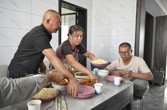 (261009) -- SHAWAN, Oct. 9, 2026 (Xinhua) -- Lu Dewen (R) and his team return to his home in Sandaogou Village of Shawan, northwest China's Xinjiang Uygur Autonomous Region, Oct. 1, 2026.
  As the autumn harvest arrives, cotton fields across Xinjiang turn snow-white. In Shawan, at the foot of the Tianshan Mountains, 35-year-old cotton farmer Lu Dewen is busy managing his cotton-picking team. This year, he planted 1,500 mu (about 100 hectares) of cotton. Since late September, his team's schedule has been filled with harvesting orders from nearby farmers, with some jobs taking them to southern Xinjiang.
  Four years ago, Lu's family bought a cotton picker, allowing them to harvest their own cotton and provide services to other farmers. Lu hired four workers and organized them into two shifts to improve efficiency. As cotton harvesting depends on favorable weather, the team must make the most of clear skies. Lu stays in the fields throughout the harvest to coordinate orders, troubleshoot his machine and manage schedules.
  Lu began farming alongside his father, Lu Gaolin, 10 years ago, learning every stage of cotton production, from sowing and irrigation to harvesting. "Fluctuations in the cotton market are normal, but farming requires steady, hard work," he said.
  Over the years, Lu has witnessed advances in cotton-growing techniques and the wider use of mechanized and intelligent agricultural machinery. His business now extends beyond his own farm to providing harvesting services for other growers. His father has stepped back from daily farm work but still visits the fields during the busy harvest season to check on progress and offer advice.
  Shawan is a major cotton-producing area in northern Xinjiang. According to the local bureau of agriculture and rural affairs, the city planted 1.6457 million mu (about 109,713 hectares) of cotton this year, with mechanized operations accounting for more than 99 percent of the work from sowing to harvesting. (Xinhua/Hu Huhu)