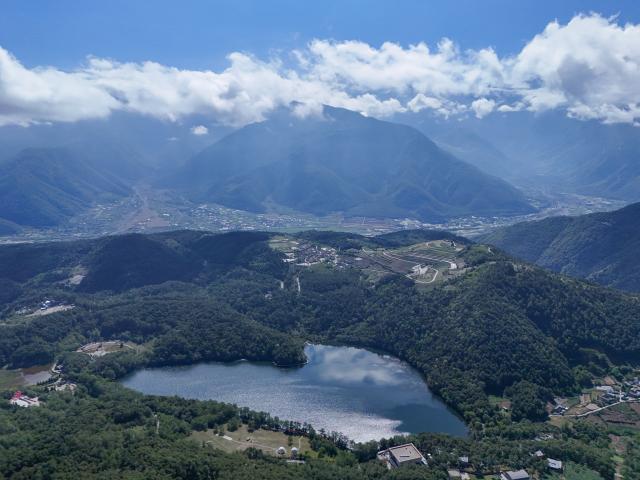 (261009) -- CHENGDU, Oct. 9, 2026 (Xinhua) -- An aerial drone photo taken on May 13, 2026 shows a view of the Yihai Lake in Mianning County of Liangshan Yi Autonomous Prefecture, southwest China's Sichuan Province. The year 2026 marks the 90th anniversary of the victory of the Long March. Sichuan became closely tied to the Red Army's activities from 1935 to 1936. During the Long March, the Red Army crossed the Jinsha River, formed the Yihai Alliance, fought their way across the Dadu River, seized the Luding Bridge, scaled snow-capped mountains and traversed grasslands, and continued their march northward to victory. (Xinhua/Wang Xi)