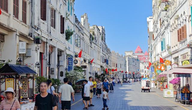 (261009) -- HAIKOU, Oct. 9, 2026 (Xinhua) -- This photo taken with a mobile phone on Oct. 1, 2026 shows tourists visiting Qilou Old Street in Haikou, south China's Hainan Province. Hainan saw 4.754 million tourist trips during the National Day holiday, marking a year-on-year increase of 13.1 percent. Total tourist spending rose 14.7 percent year on year to 6.875 billion yuan (about 1.02 billion U.S. dollars), according to the Hainan provincial department of tourism, culture, radio, television and sports. (Xinhua/Guo Cheng)