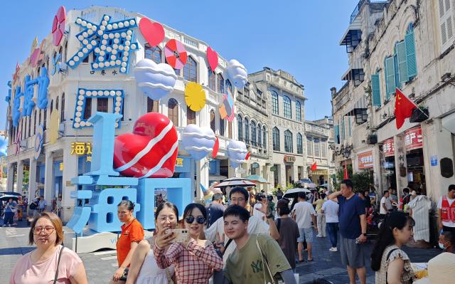 (261009) -- HAIKOU, Oct. 9, 2026 (Xinhua) -- This photo taken with a mobile phone on Oct. 1, 2026 shows tourists visiting Qilou Old Street in Haikou, south China's Hainan Province. Hainan saw 4.754 million tourist trips during the National Day holiday, marking a year-on-year increase of 13.1 percent. Total tourist spending rose 14.7 percent year on year to 6.875 billion yuan (about 1.02 billion U.S. dollars), according to the Hainan provincial department of tourism, culture, radio, television and sports. (Xinhua/Guo Cheng)