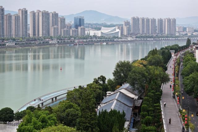 (261009) -- ANKANG, Oct. 9, 2026 (Xinhua) -- An aerial drone photo taken on Oct. 8, 2026 shows the scenery along the Hanjiang River in Ankang, northwest China's Shaanxi Province.
  The city of Ankang receives a surging number of tourists, thanks to the Xi'an-Ankang high-speed railway officially put into operation on Sept. 28 this year. The travel time between Xi'an, capital of Shaanxi, and Ankang has been slashed to less than one hour. (Xinhua/Shao Rui)