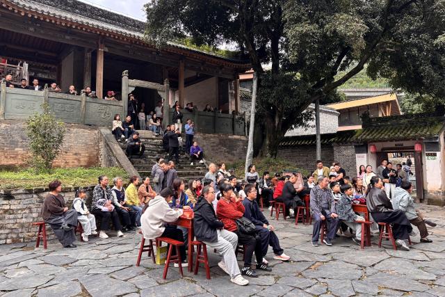 (261009) -- ANKANG, Oct. 9, 2026 (Xinhua) -- Tourists watch a performance inside a historical guild house in Ziyang County of Ankang, northwest China's Shaanxi Province, Oct. 3, 2026.
  The city of Ankang receives a surging number of tourists, thanks to the Xi'an-Ankang high-speed railway officially put into operation on Sept. 28 this year. The travel time between Xi'an, capital of Shaanxi, and Ankang has been slashed to less than one hour. (Photo by Huang Jie/Xinhua)