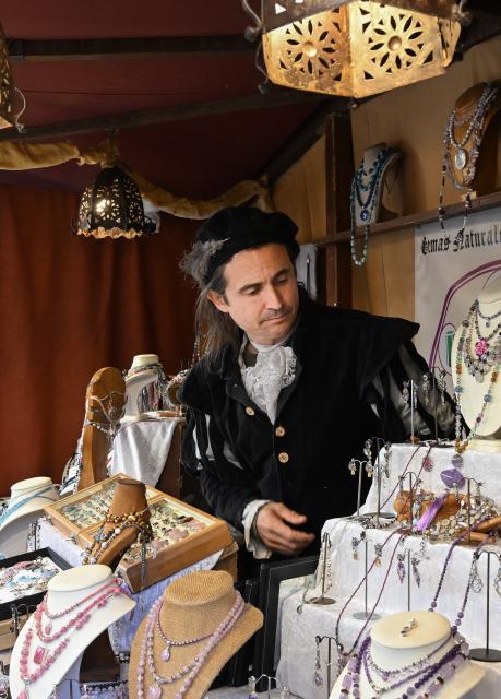 (261009) -- ALCALA DE HENARES, Oct. 9, 2026 (Xinhua) -- A stallholder arranges goods at a market during the Cervantes Week celebration in Alcala de Henares, Spain, Oct. 9, 2026. Cervantes Week is being celebrated from Oct. 8 to 12 in Alcala de Henares, the hometown of Spanish writer Miguel de Cervantes. The annual festival honors Cervantes, one of Spain's greatest literary figures. (Xinhua/Cheng Min)