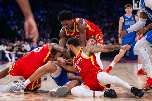 (261010) -- MACAO, Oct. 10, 2026 (Xinhua) -- Cooper Flagg (C) of Dallas Mavericks saves the ball during the 2026-2027 NBA preseason game between Houston Rockets and Dallas Mavericks in Macao, south China, Oct. 9, 2026. (Xinhua/Cheong Kam Ka)