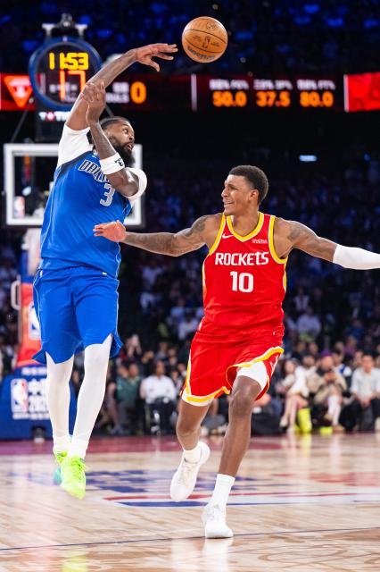 (261010) -- MACAO, Oct. 10, 2026 (Xinhua) -- Naji Marshall (L) of Dallas Mavericks passes the ball during the 2026-2027 NBA preseason game between Houston Rockets and Dallas Mavericks in Macao, south China, Oct. 9, 2026. (Xinhua/Cheong Kam Ka)